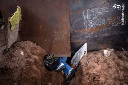 کندن زمین از زیر دیوار مرزی از سوی یک مهاجر هندوراسی برای عبور به آن سوی دیوار مرزی مکزیک و ایالات متحده آمریکا.