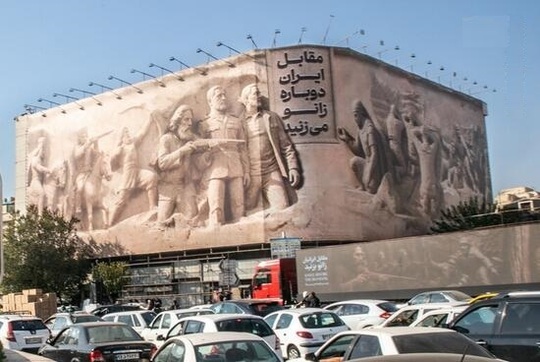 جدیدترین طرح دیوارنگاره میدان انقلاب تهران با شعار «مقابل ایران دوباره زانو می‌زنید» نصب شد.